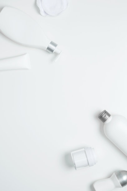 白色背景的化妆美容产品。瓶子和管与品牌模拟。护肤美容理念。俯视图，平面布局，复制空间图片下载