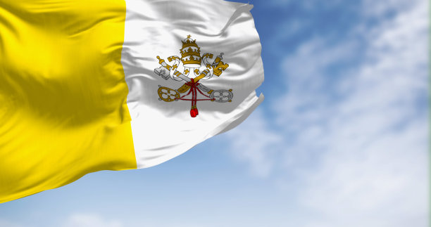 在一个晴朗的日子里，梵蒂冈城的旗帜在风中飘扬图片下载