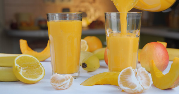 甜瓜香蕉橙冰沙在新鲜水果的背景下倒进玻璃杯图片下载