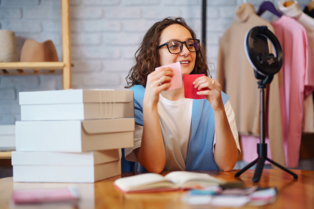 在线商店的年轻老板正在录制准备包裹运输的实时视频。图片下载