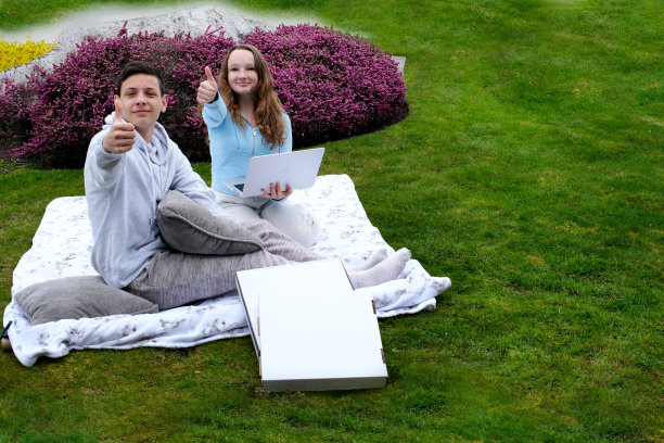 两个十几岁的青少年展示班披萨盒送货上门野餐生日日期披萨送货广告订购网上快餐暑假和朋友一起度过有广告文字的地方图片下载