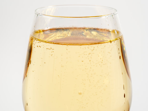 浅色背景下的一杯白葡萄酒。图片下载