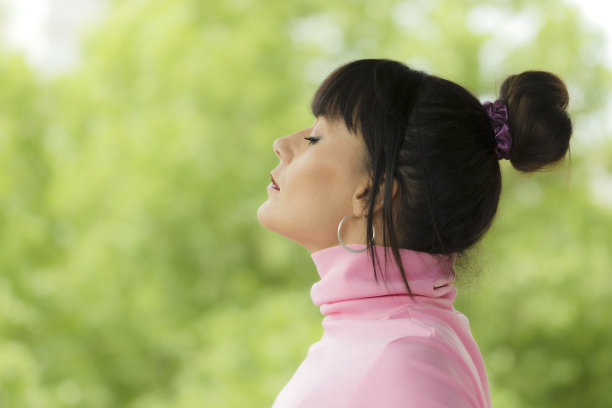 早晨在家阳台呼吸新鲜空气的放松女子。女性在大自然中放松呼吸，以获得平静的精神健康。女人在健康的呼吸活动中放松。本空间图片下载