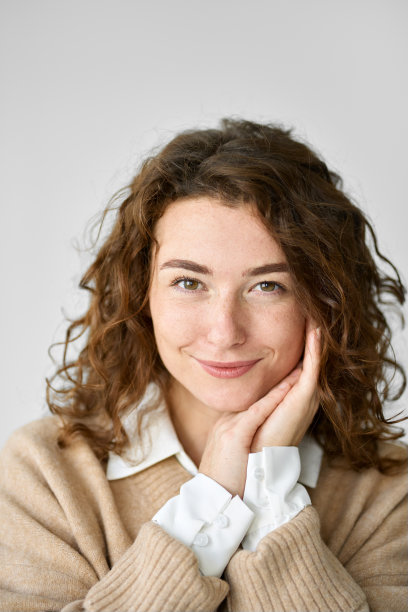 年轻快乐的漂亮女子看着相机孤立在白色，垂直的肖像。图片下载