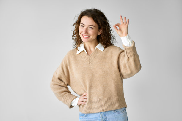 快乐的年轻女子模特在白色上展示了ok的手势。图片下载