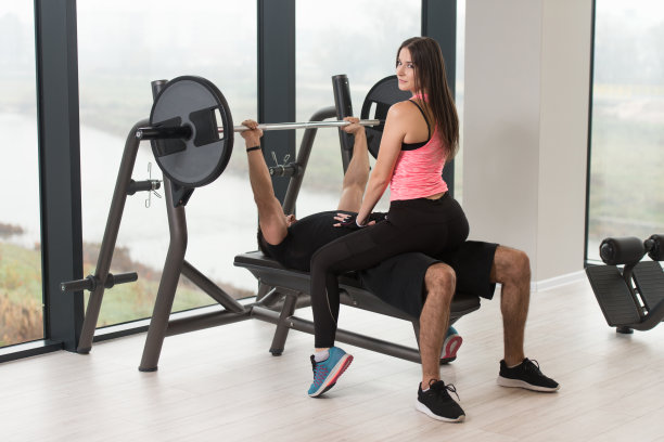 男子与健身教练在长凳上训练胸部图片下载