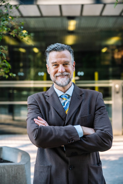 乐观的成年商人双臂交叉看着镜头图片下载