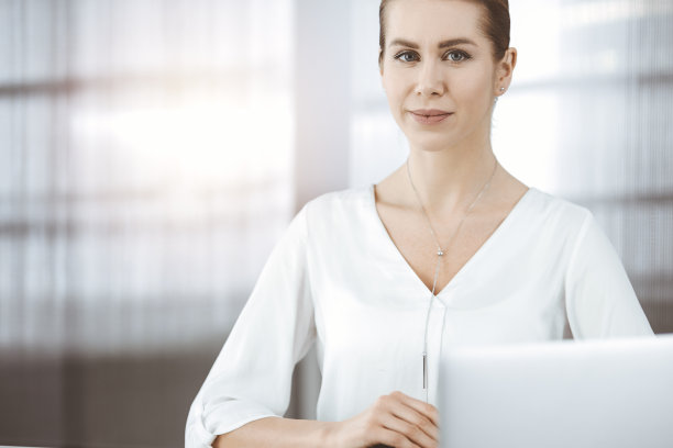 女商人坐在阳光明媚的办公室里看着镜头图片下载