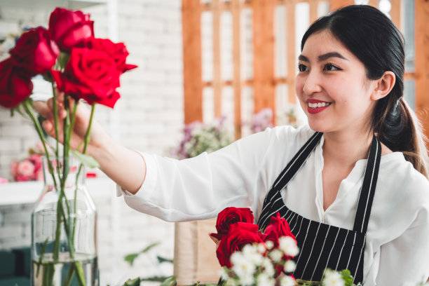 花店里，年轻的花商正在一丝不苟地修剪鲜花，准备制作一个漂亮的花瓶。图片下载