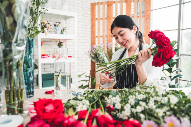 花店里，年轻的花商正在一丝不苟地修剪鲜花，准备制作一个漂亮的花瓶。图片下载