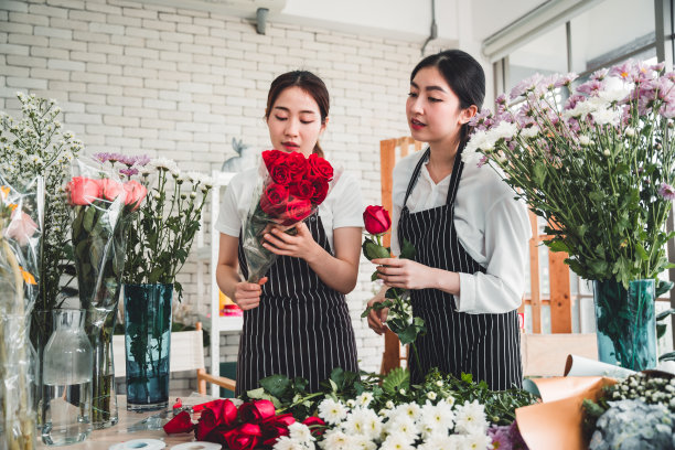 在一家花店里，两名女职员精心地为顾客整理鲜花。图片下载
