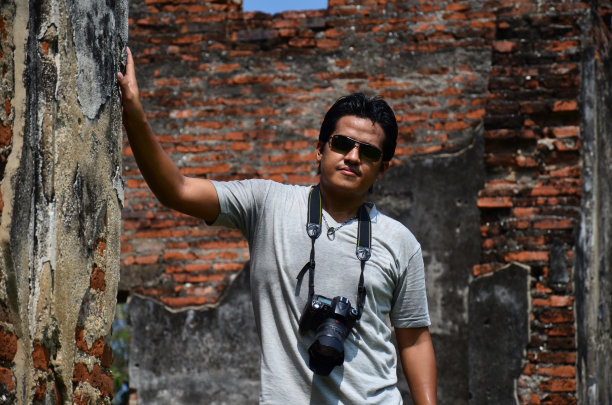 泰国男子摄影师旅行者，人们旅游参观和使用数码相机拍摄照片，在罗布武里，罗布武里市的大使官邸或Wichayen住宅古代遗迹图片下载