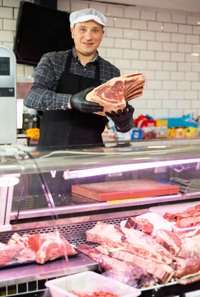 成年男子把牛排骨放在橱窗里图片下载
