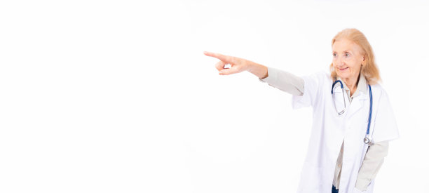 老人微笑着快乐的医生用手指着复制空间，自信地孤立在白色背景上老年医生女医生看着空白的空间医疗保健医疗保险概念图片下载