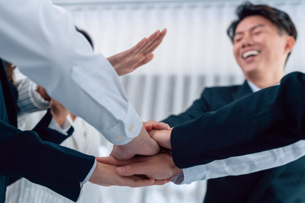 下视图部分手连接堆栈作为办公室和谐的象征图片下载