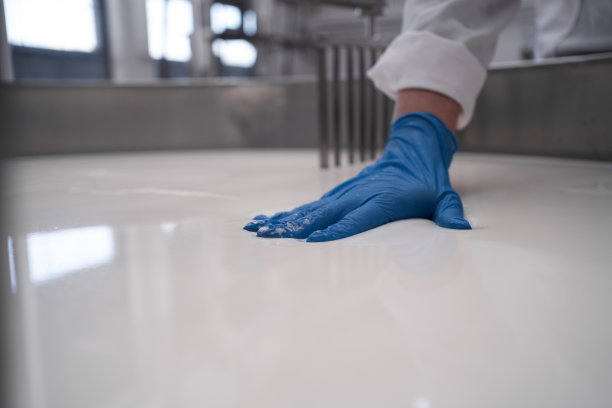 专业工厂用手处理凝乳奶酪。奶酪制作机是在制作过程中生产不同品种奶酪的行业。图片下载