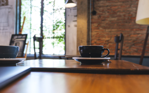 两杯咖啡和一台放在木桌上的笔记本电脑图片下载