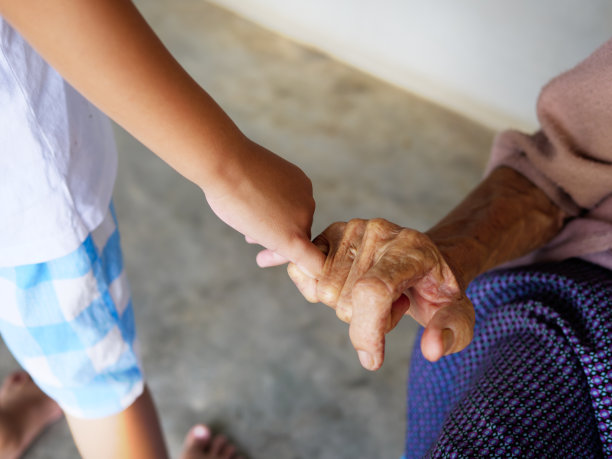 老年妇女的手和幼儿的手互相钩住对方的小指。图片下载