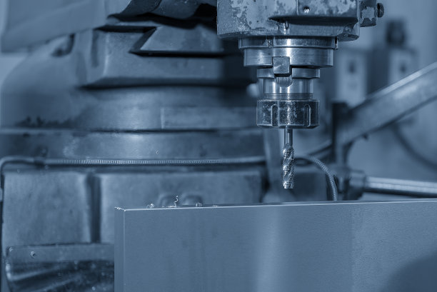 浅蓝色场景中数控铣床上的攻丝过程。图片下载