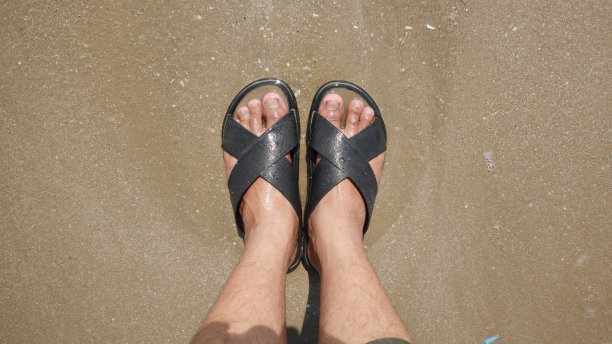 沙滩上的黑色凉鞋图片下载