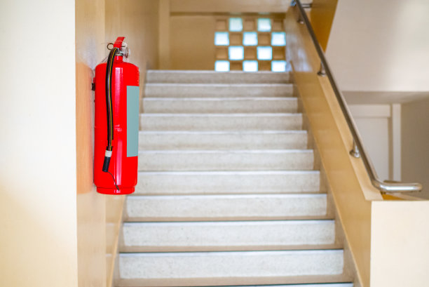 一个灭火器挂在楼梯上。消防安全理念。图片下载