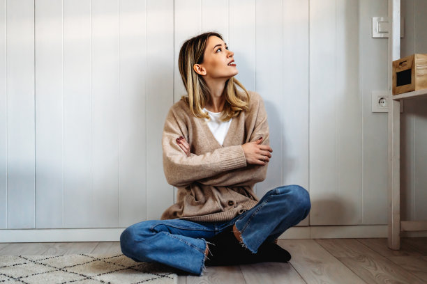 人们休闲的生活方式理念。年轻的女性穿着时髦的衣服笑着在家里休息图片下载