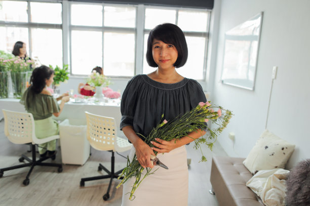 一个中年亚洲女人的花商肖像图片下载