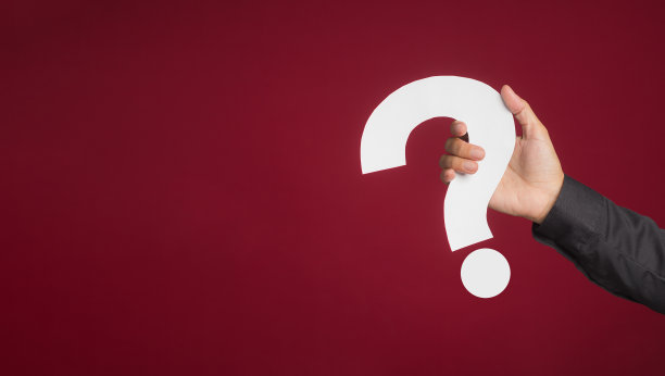 一个穿黑衬衫的女人的手拿着一张白色的问号纸，站在红色的背景上。图片下载