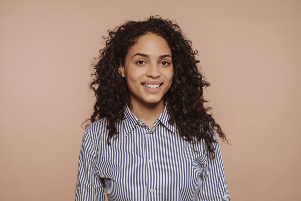 年轻微笑的多种族女人，卷发图片下载