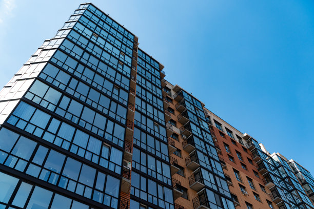 公寓住宅和住宅立面。一栋新建的高级住宅楼的残片。蓝天为背景图片下载