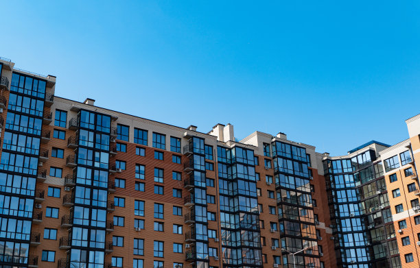 阳光明媚的日子里，蓝天下的现代公寓楼图片下载