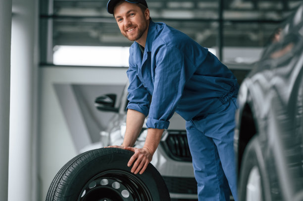 穿蓝制服的人在汽车维修处工作图片下载