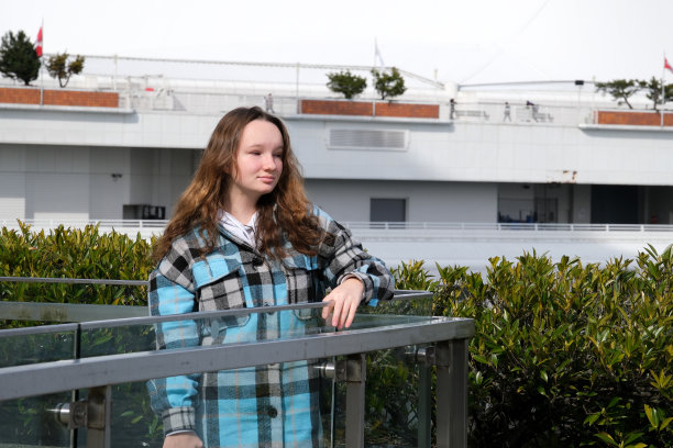 十几岁的女孩走在加拿大广场附近，在帆船的背景下，在摩天大楼的背景下，太平洋的船只，春天，秋天，街道上，一天，城市里明亮的阳光图片下载