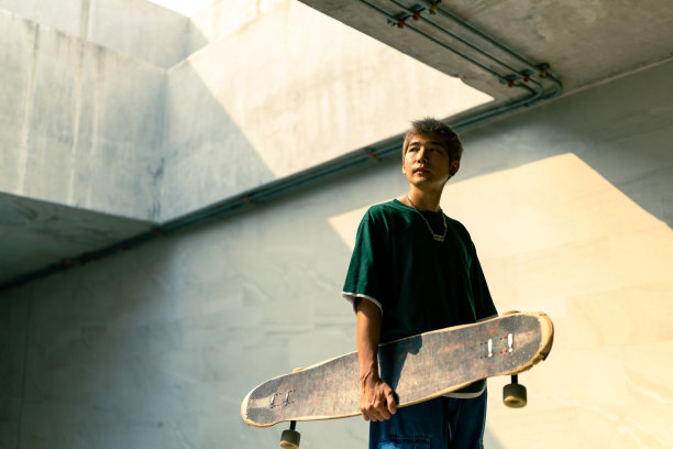 一名亚洲男子在行人过街隧道滑长板滑板。图片下载
