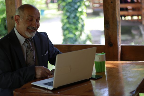 老年商人在笔记本电脑上工作图片下载