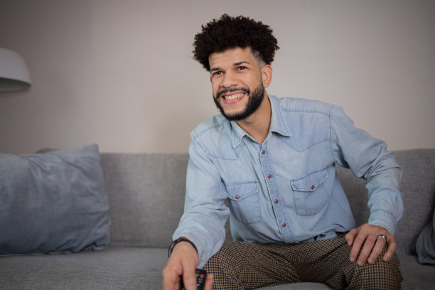 男人在家里享受他最喜欢的电视节目图片下载