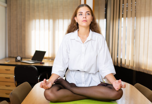 一个小女孩在会议室里做瑜伽的照片图片下载