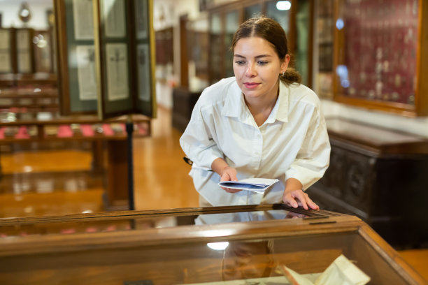 拿着小册子参观博物馆的年轻女子图片下载