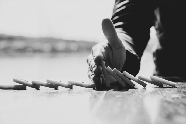 女手和木桌上的多米诺骨牌，游戏，黑白照片图片下载