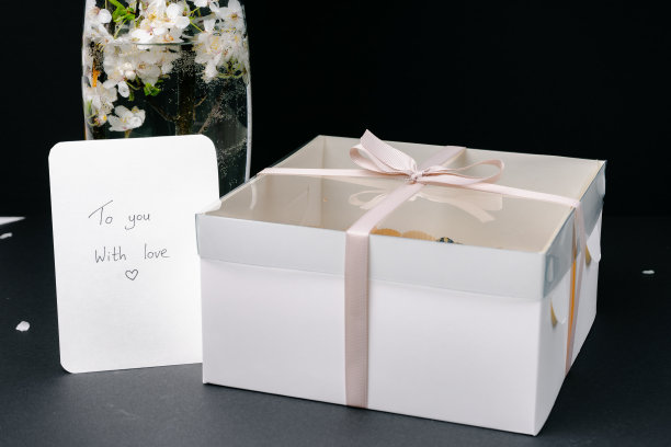 一个白色的礼品盒和一张黑底花纸卡图片下载