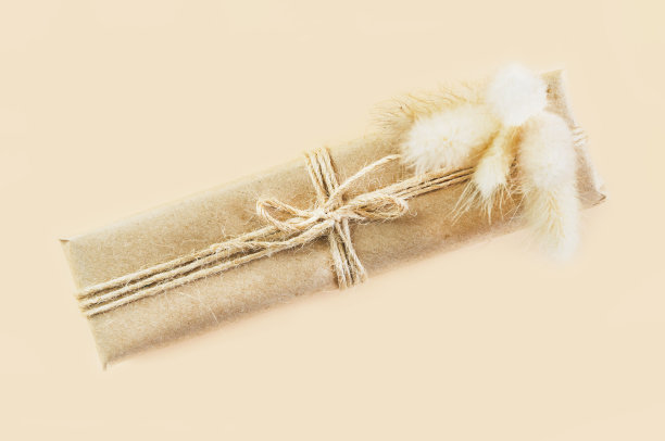 礼品盒用牛皮纸包装，米色背景上系上麻绳。老式盒子由棕色环保纸制成图片下载