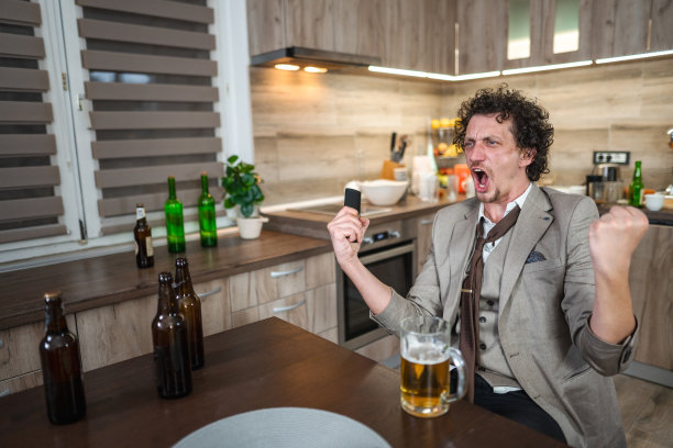 兴奋的白人一边看着电视上的足球比赛一边欢呼，喝着啤酒图片下载