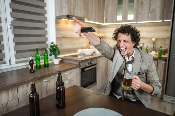 兴奋的白人一边看着电视上的足球比赛一边欢呼，喝着啤酒图片下载