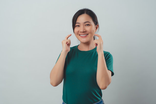 亚洲女人开心地露出露齿的微笑，孤立地站在白色的背景上。图片下载