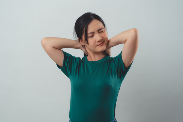 一名亚洲妇女因颈部疼痛而孤立站立。图片下载