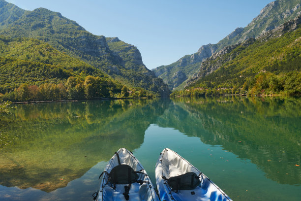 两艘皮艇在河岸上的田园诗般的照片。在绿色森林地区和山脉的背景下图片下载