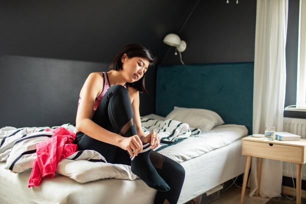 年轻女子穿上袜子，准备去锻炼图片下载