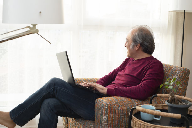 男人在家工作时在笔记本电脑上打字图片下载