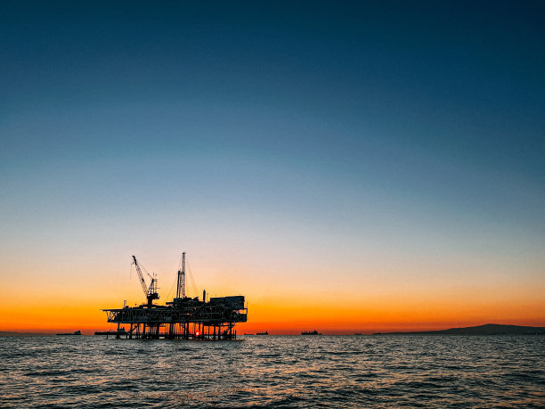亨廷顿海滩海岸附近的一个海上石油钻井平台的广角低角度日落照片图片下载