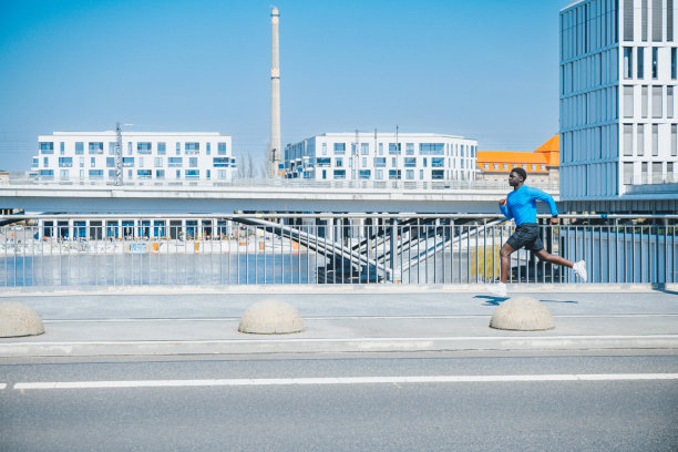 年轻运动员在现代柏林的一座桥上奔跑图片下载